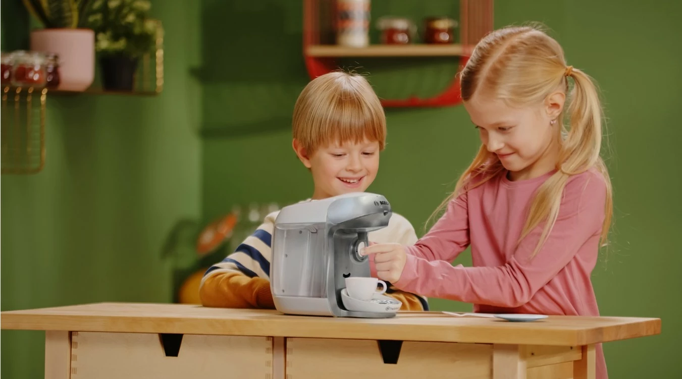 Igrača kavni aparat Bosch Tassimo 9231, s zvočnimi in tekočimi učinki, s skodelico, krožnikom, žličko in 2 kapsulama, srebrn